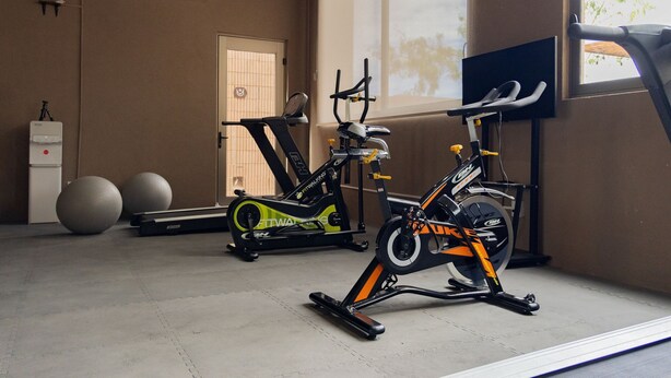 An indoor gym with exercise equipment, a door, and a window. - Evamar San Carlos  (San Carlos)