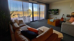 A living room with a sofa, a coffee table, and a television. - Wamoon Retreat ~ Luxe House - Gateway to Wilsons Prom  (Yanakie)