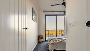 A bedroom with a bed, a potted plant, a window with a view, and a ceiling fan. - Wamoon Retreat ~ Luxe House - Gateway to Wilsons Prom  (Yanakie)