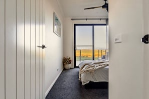 A bedroom with a bed, a potted plant, a window with a view, and a ceiling fan. - Wamoon Retreat ~ Luxe House - Gateway to Wilsons Prom  (Yanakie)