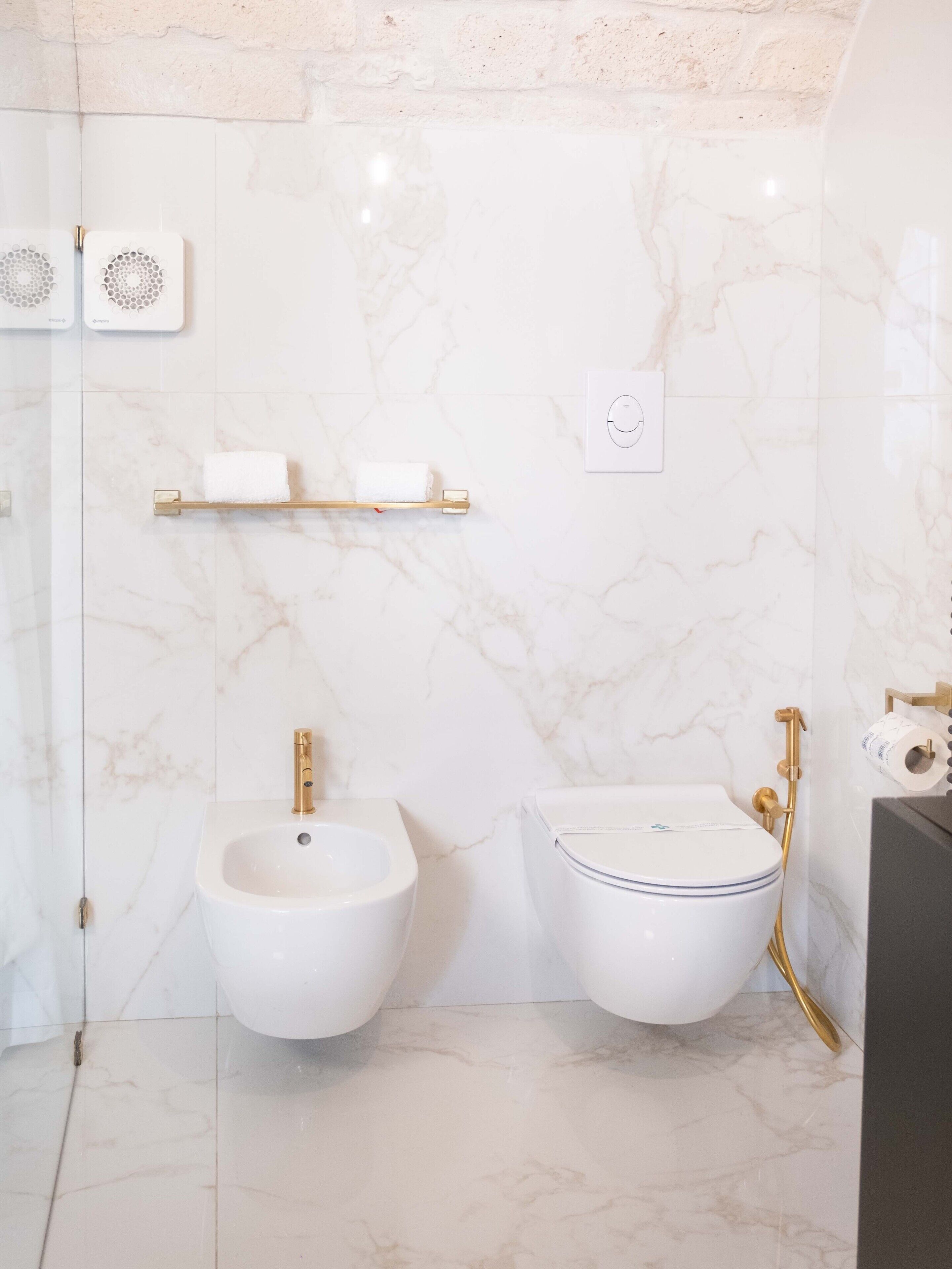 Een badkamer met een hygiëneschuimer, wastafel en toilet.