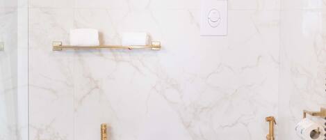 Une salle de bain équipée d’un bidet, d’un lavabo et de toilettes.