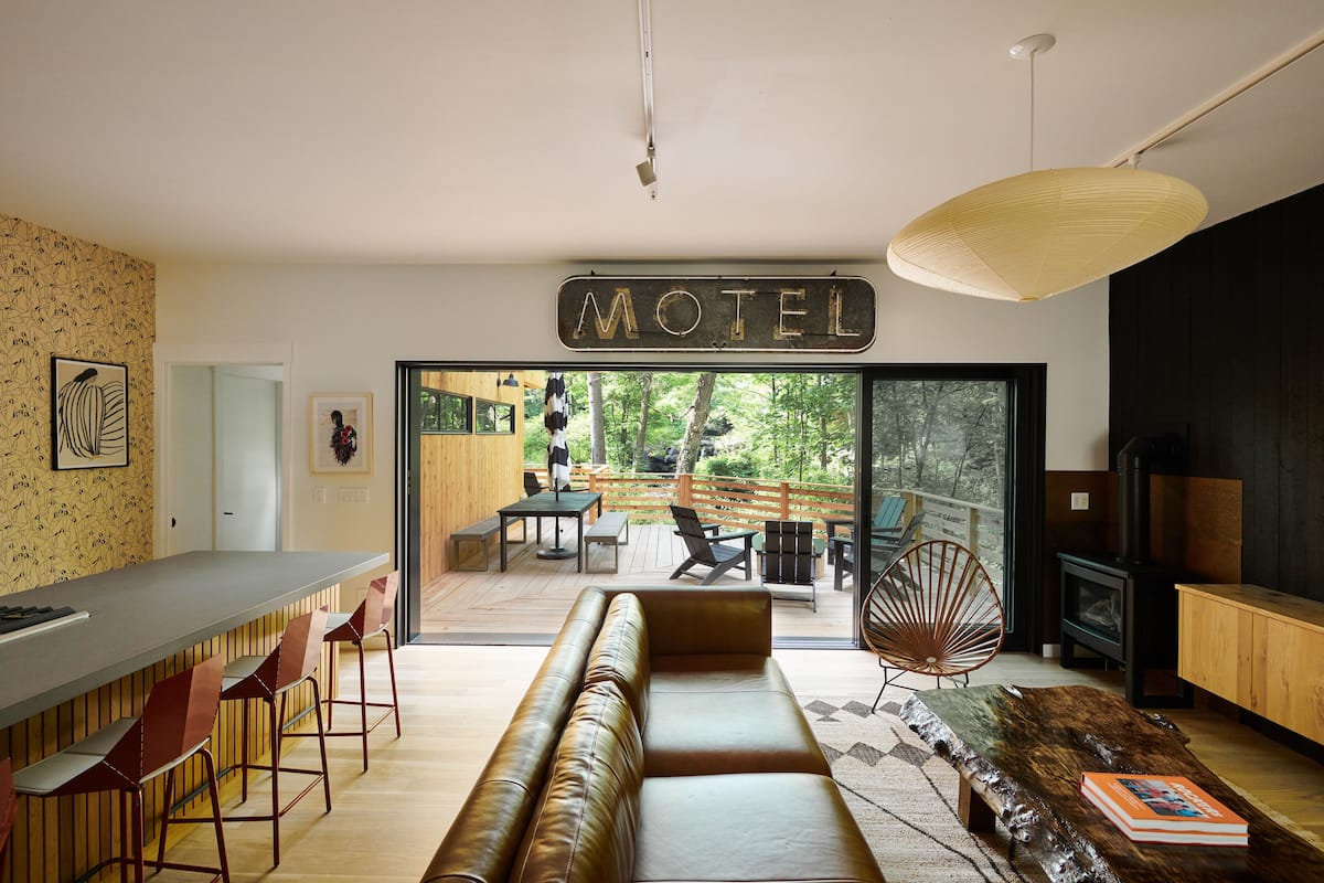 A modern motel interior with a bar, seating area, and a view of the outdoors.
