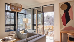 A modern living room with a grey sofa, a small round table, and a hanging light fixture.