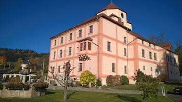 Ein großes, mehrgeschossiges Gebäude mit einer symmetrischen Fassade, zahlreichen Fenstern und einem zentralen Turm.