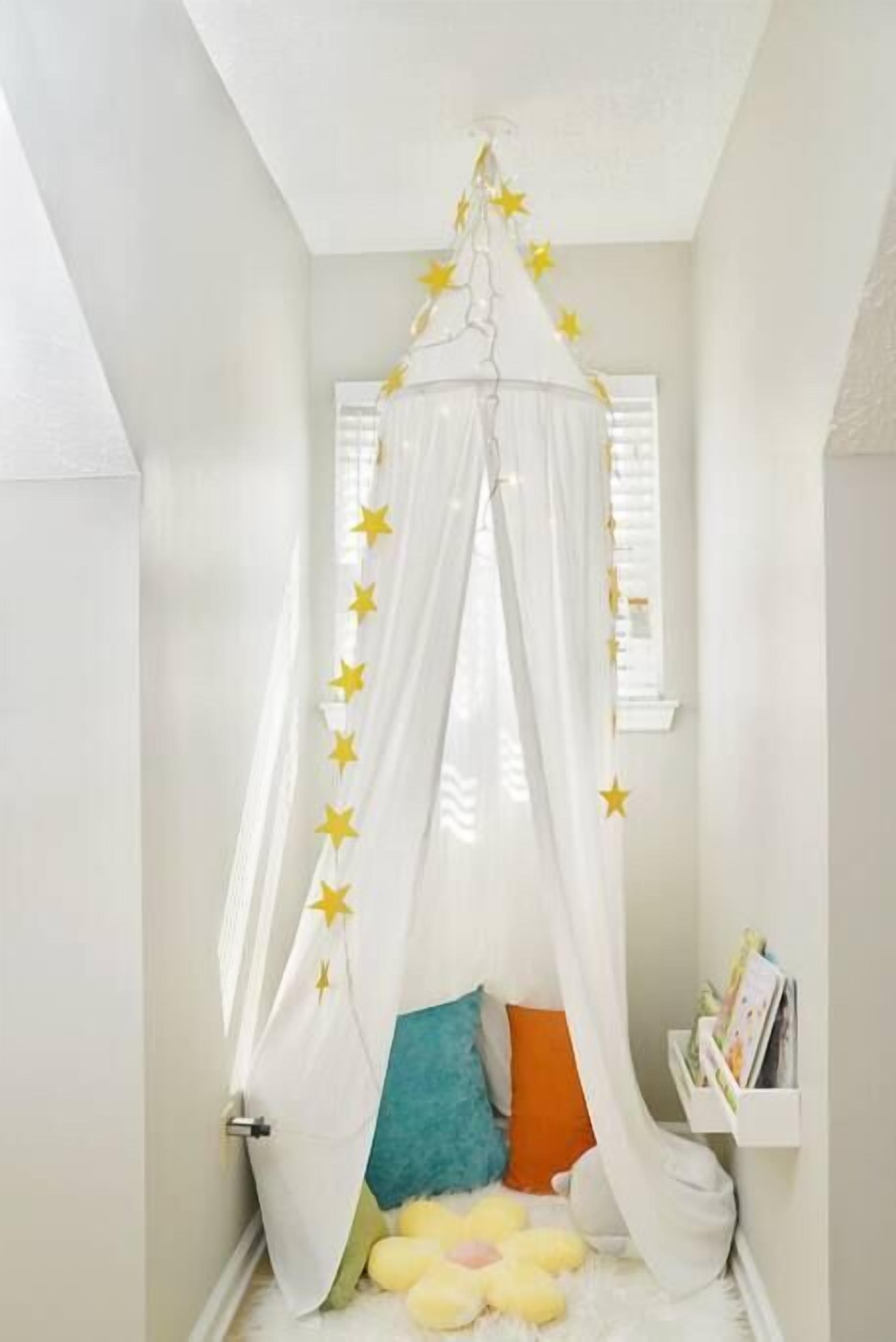 Un dormitorio acogedor con cama a dosel, adornos con motivos de estrellas y un peluche en el suelo.