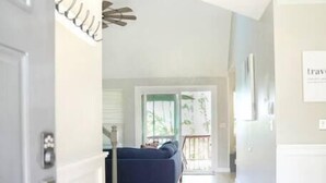 A hallway with a bench, a sofa, and a staircase leading to a balcony.