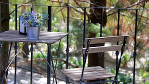 A wooden bench and table with a potted plant on a balcony. - Sublime Valley Resort (Villa de Allende)