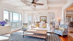 A spacious living room with a white sofa, patterned armchairs, a wooden coffee table, and a ceiling fan. - Grey Goose: Oceanfront Escape, Backyard Oasis + Prime Location (Murrells Inlet)