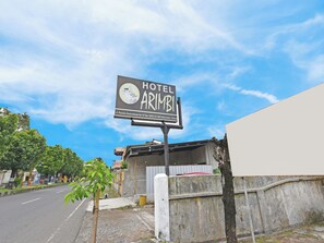 Un letrero que dice 'HOTEL ARIMBI' con información de contacto.