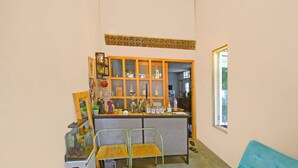 Un espacio habitable compacto con kitchenette, un sofá azul y una pequeña zona de comedor.