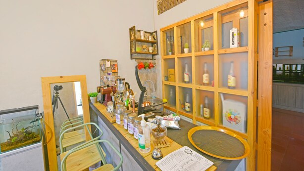 Una zona de bar con estantes de madera, una máquina de café y varias botellas.