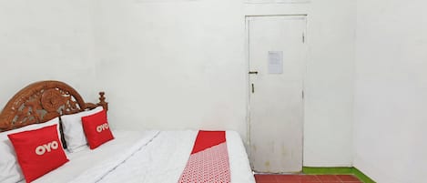 Quarto com cama, porta e colcha estampada.