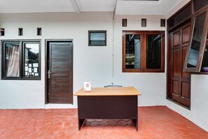 Una habitación con escritorio, puerta y ventana.