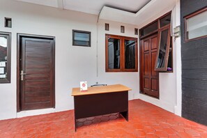 Una habitación con un escritorio de madera, una puerta y una ventana.