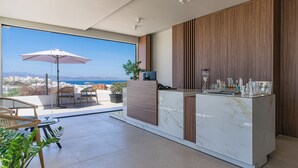 A modern kitchen with a marble countertop, wooden cabinets, and a view of the sea. - El mar Naxos  (Naxos)