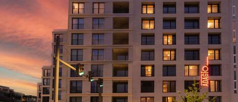 A multi-story hotel with a modern facade, illuminated windows, and a visible restaurant on the ground floor.