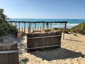 A beach with a wooden structure and a thatched roof. - Casa Alvino, Castiglione della Pescaia, Roccamare, private beach (Castiglione della Pescaia)
