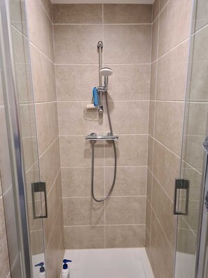 Enjoy a refreshing shower experience with a wall-mounted showerhead and handheld shower attachment.