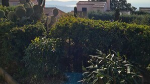 A rural landscape with a clear sky, a small building with a tiled roof, and cactus plants. - charming apartment - view of the Cavalaire bay (La Croix-Valmer)