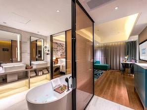 A modern bathroom with a freestanding bathtub, a large mirror, and a vanity with a sink. - Ramada Encore by Wyndham Guangzhou Jiangnan West (Guangzhou)