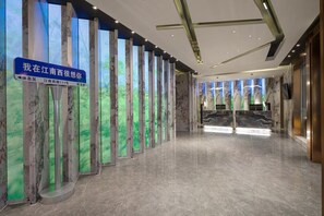 A modern hotel lobby with a marble floor, vertical light panels, and a directional sign. - Ramada Encore by Wyndham Guangzhou Jiangnan West (Guangzhou)
