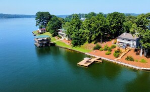 A lakeside property with a dock, a covered boat launch, and a large house with a deck. - Opening Calendar 45 Days Out - Amazing View Lakefront Home with private dock (Jacksons' Gap)