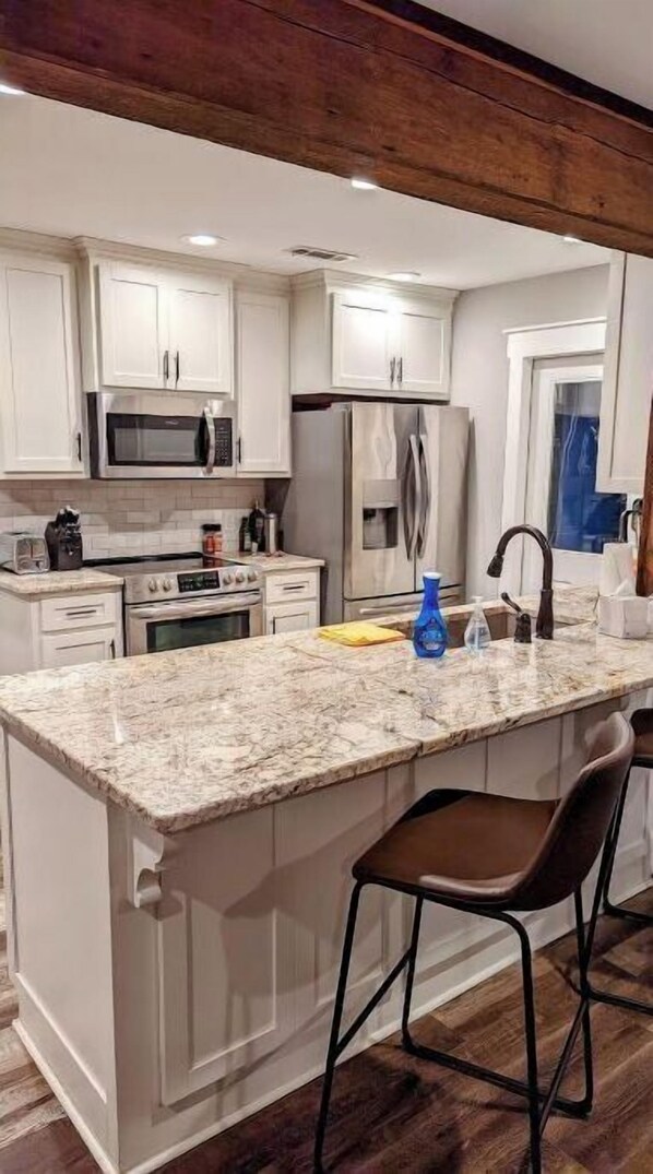 A kitchen with white cabinets, stainless steel appliances, a granite countertop, and a wooden ceiling. - Opening Calendar 45 Days Out - Amazing View Lakefront Home with private dock (Jacksons' Gap)