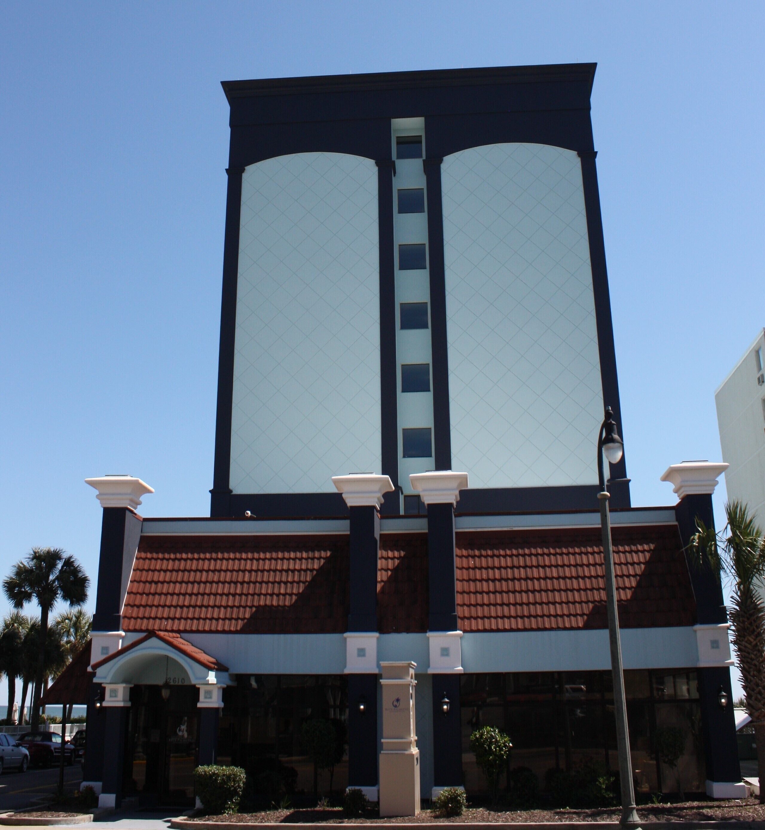 A building with a large central tower, a red-tiled roof, and a white facade.