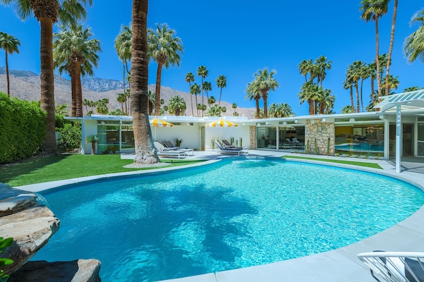 Kidney bean-shaped pool in spacious yard with heaters, misting machines, views.