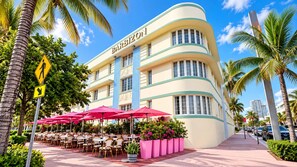 Un hôtel BarBison doté d’une terrasse et de palmiers.