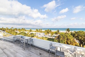 A balcony with a view of the beach and ocean. - Oceanfront Oasis: 2-BR Apartment on Ocean Drive (Miami Beach)