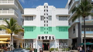 A hotel with a central entrance, multiple floors, and a green awning. - Oceanfront Oasis: 2-BR Apartment on Ocean Drive (Miami Beach)