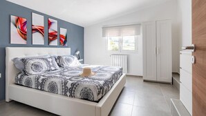 Une chambre à coucher avec un lit, une armoire et une fenêtre.