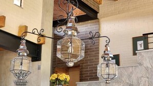 A modern interior with hanging glass lanterns, a brick wall, and a wooden ceiling.