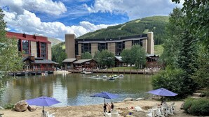 A lakeside resort with a sandy beach, lounge chairs, and umbrellas. - BEST LOCATION! Ski-In Ski-Out - Copper Mt - HotTub, Sleeps 8 (Frisco)