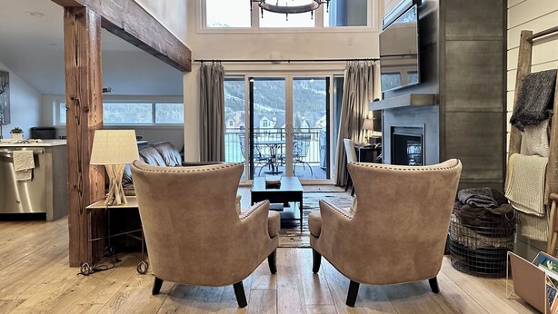 A spacious living room with a high ceiling, a fireplace, and a view of the outdoors. - BEST LOCATION! Ski-In Ski-Out - Copper Mt - HotTub, Sleeps 8 (Frisco)