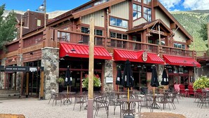 A wooden building with red awnings, outdoor seating, and a sign for 'Drink Beer Outside'. - BEST LOCATION! Ski-In Ski-Out - Copper Mt - HotTub, Sleeps 8 (Frisco)