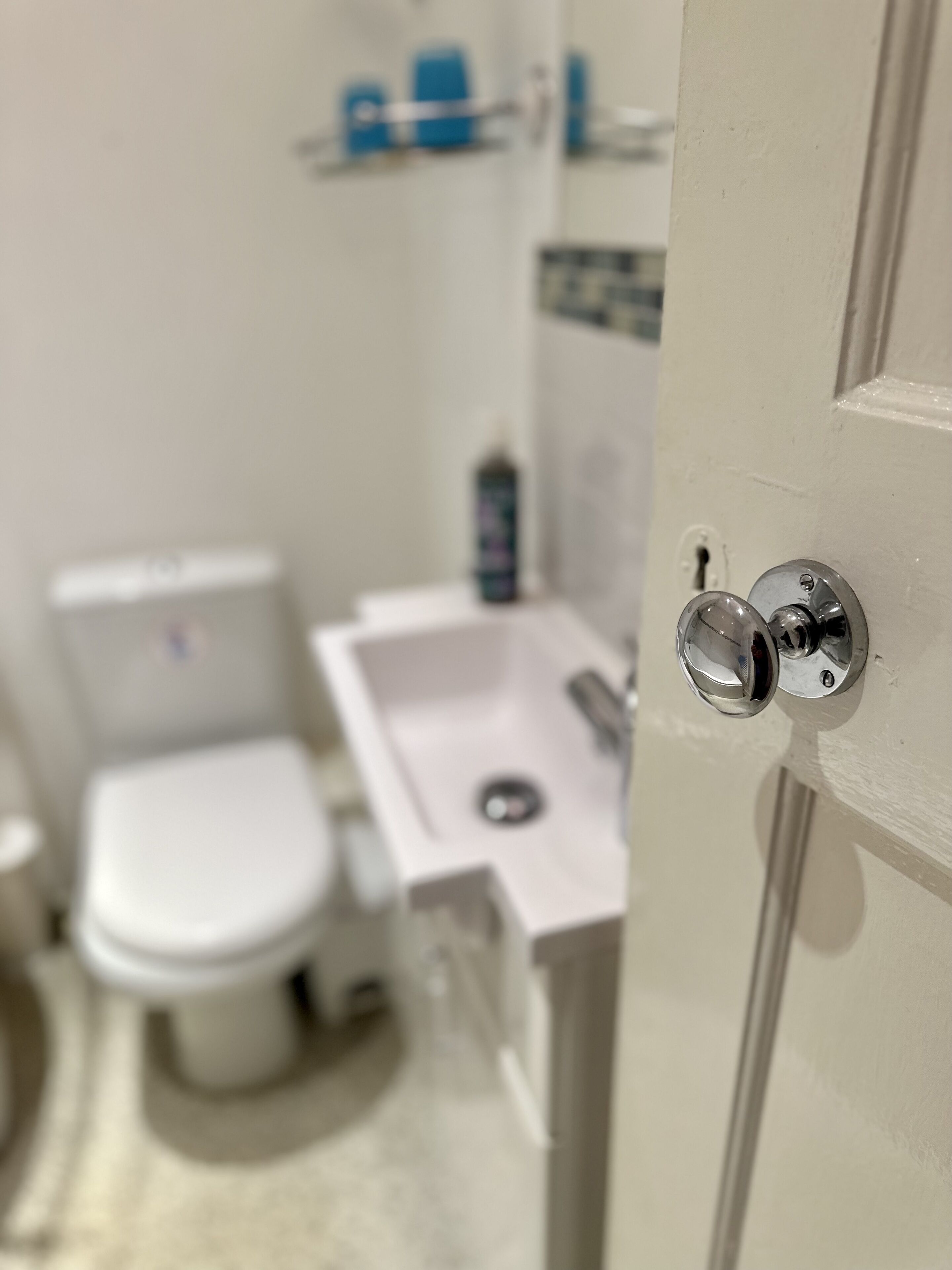 A bathroom with a toilet, sink, and a mirror.