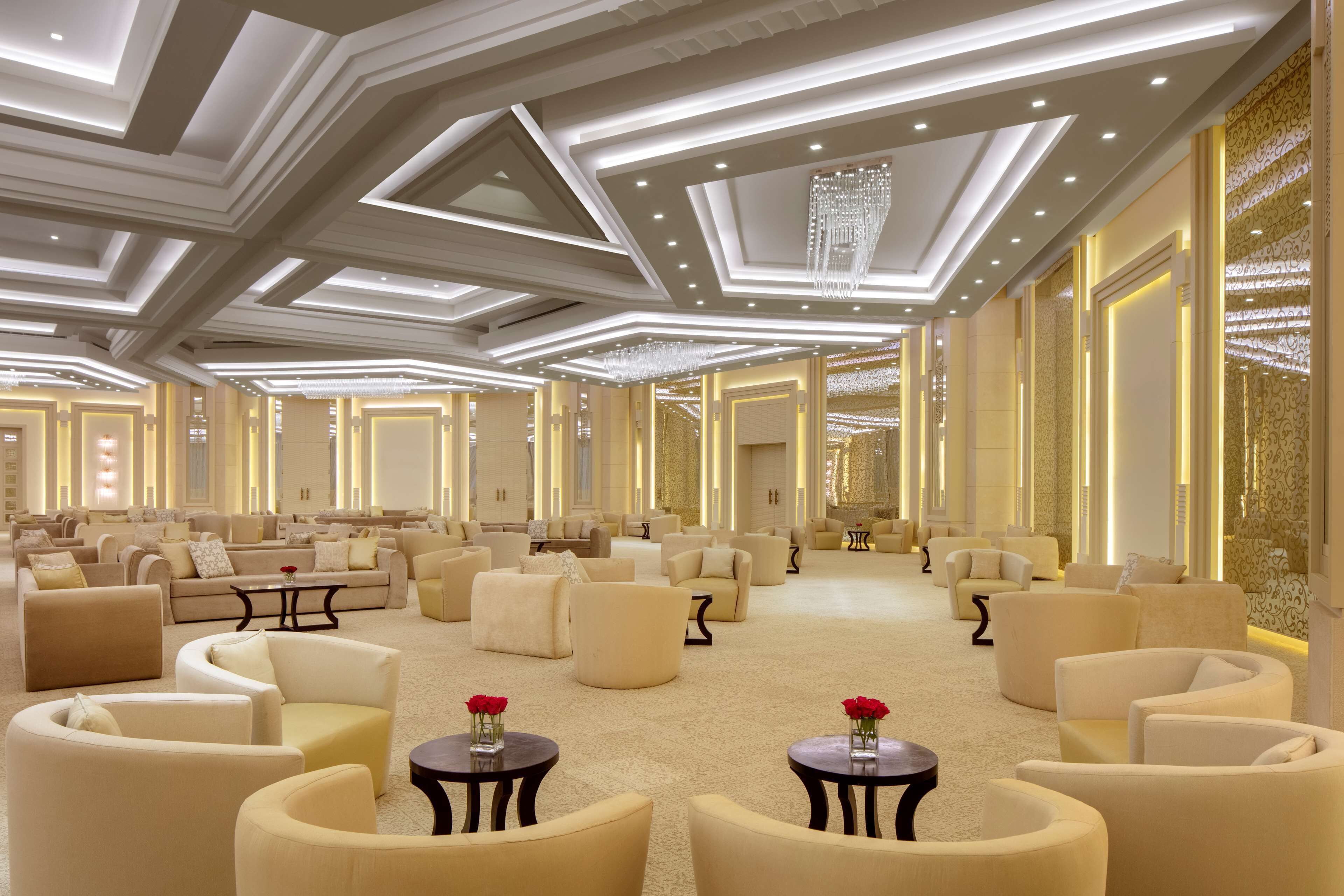 Un salon spacieux et élégamment décoré, offrant de nombreuses options d’assises et agrémenté d’un lustre.