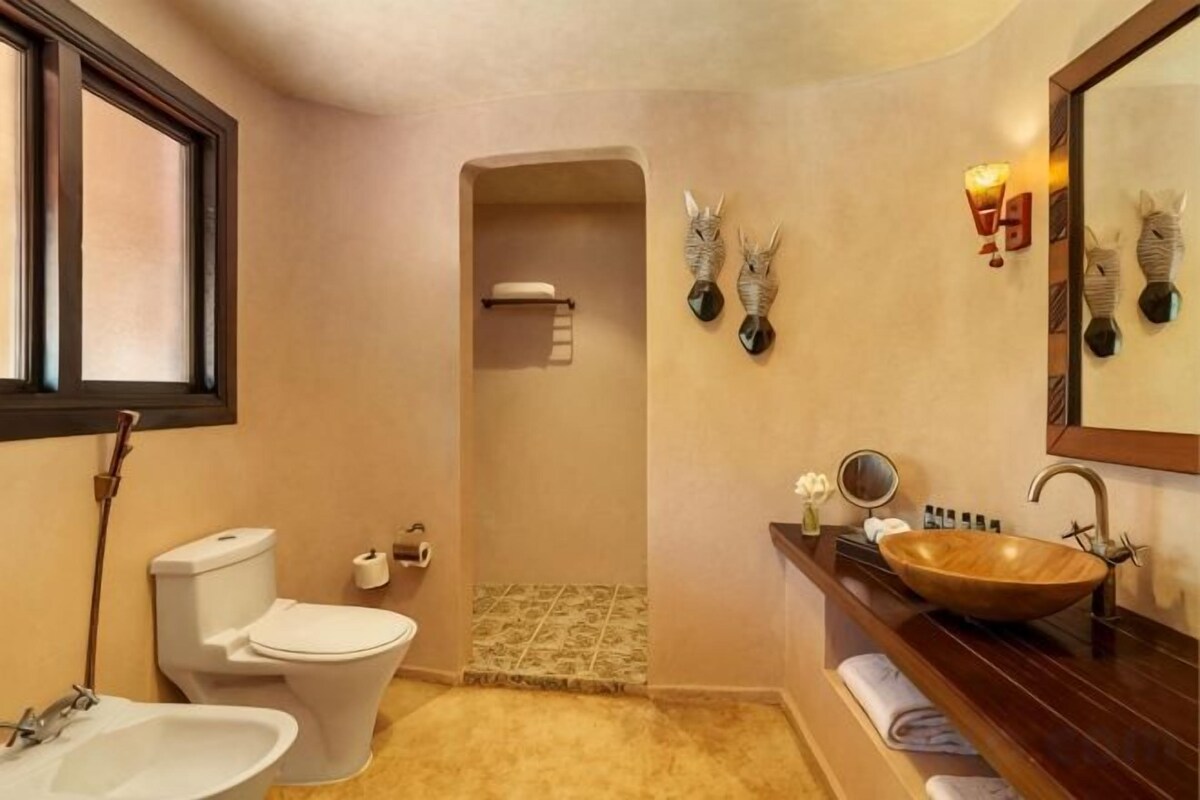 A bathroom with a toilet, sink, and shower.