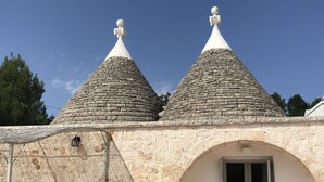 A stone building with two conical roofs and a door. - TRULLO SUITE 'THE QUEEN' in Itria Valley with swimming pool (Martina Franca)