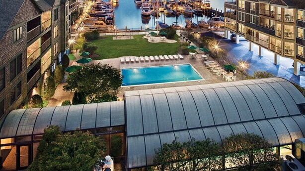 Un port de plaisance avec des bateaux, une piscine et un immeuble doté de nombreux balcons.