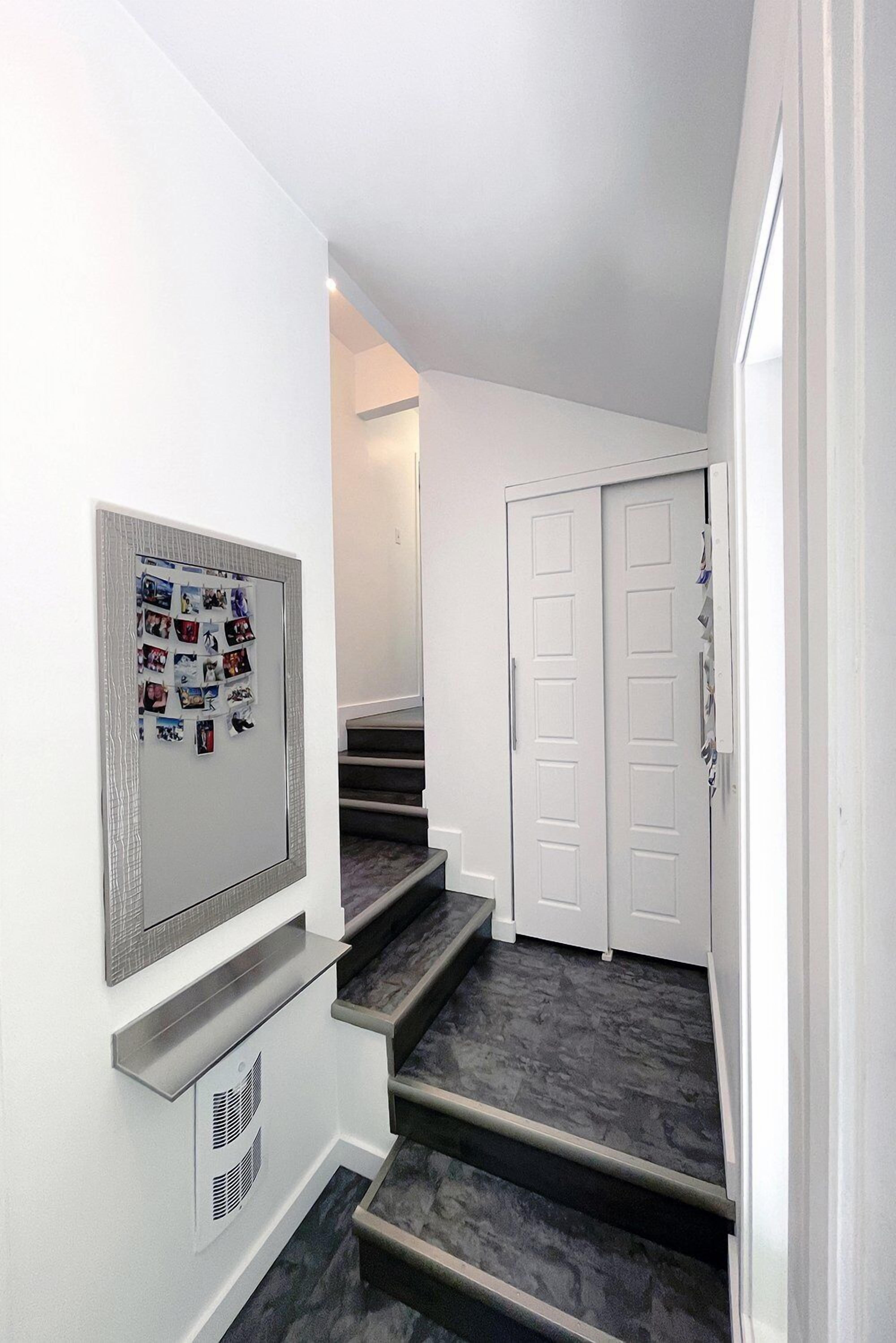 A staircase leading to a second floor with a bulletin board on the wall.