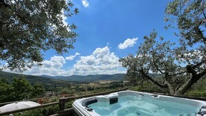 A hot tub with a clear view of the surrounding landscape, including trees and distant hills. - Villa in Sant'angiolo with 5 bedrooms sleeps 12 (Sant'angiolo)