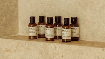 Ein Regal mit sechs Flaschen Santal 33 Conditioner/Shampoo.