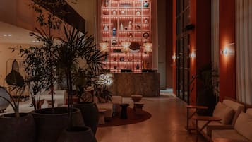 En lobby med receptionsdisk, siddeområde og en væg med dekorative vaser.