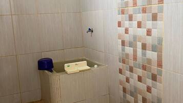 A bathroom with a shower, a sink, and a toilet.