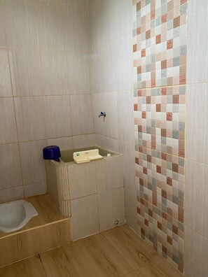 Une salle de bain avec une douche, un lavabo et des toilettes.