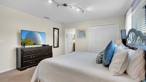 Relax in this serene bedroom with a large bed, flat-screen TV, and a dresser for your convenience.